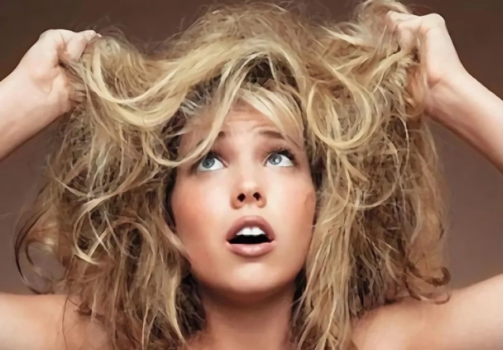 Dry and Damaged Hair Care: How to Repair and Restore Hair 1 Woman frustrated with dry and damaged hair showing need for proper dry and damaged hair care routine