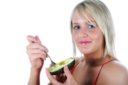 Healthy woman eating avocado showing how many calories are in one avocado serving