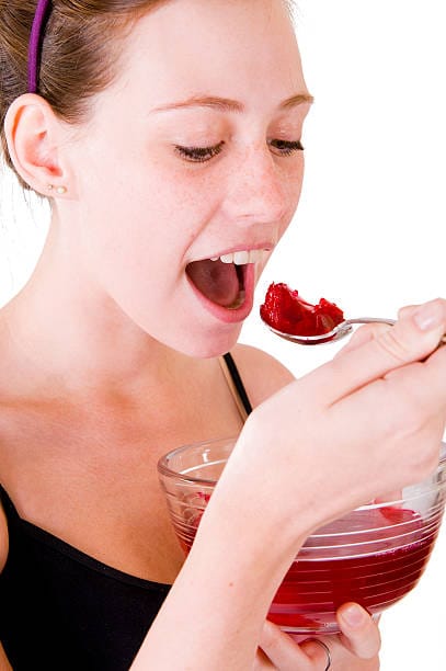Woman enjoying low calorie jelly dessert made with sugar-free red fruit flavor